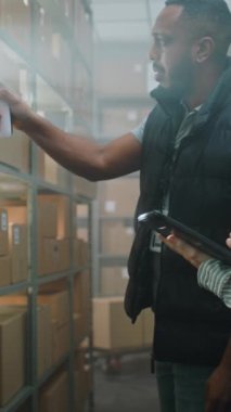 Afrikalı Amerikalı Çalışan Tarayıcı ile E-Ticari Ürünler Paketlerini Tarıyor. Kulaklıktaki Kadın Depo Şirketi Tablet Bilgisayar kullanıyor, Nakliye Bilgilerini Denetliyor. Teslimat Teslimat Merkezi.