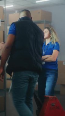 Envanter uzmanı meslektaşlarına talimat veriyor, tablet bilgisayar kullanıyor. Çeşitli depo çalışanları tasnif merkezinde kutular, e-ticaret online siparişler, nakliye malları ile çalışırlar. Dikey çekim.