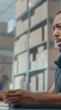 Afrikalı Amerikalı lojistik müşteri destek uzmanı müşteriyle kulaklık görüşmeleri yapıyor, bilgisayar kullanıyor, posta servisinde çalışıyor. Teslimat için kutu taşıyan tasnif merkezi çalışanları. Çevrimiçi depo.