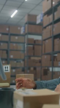 Afro-Amerikan lojistik koordinatörü. Müşteri ile telefon görüşmeleri yapıyor, bilgisayar kullanıyor. Posta servisinde ya da E-ticaret deposunda çalışıyor. Merkez çalışanı kutulara bakıyor. Dikey çekim.