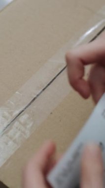 Depo Tezgâhtarının Kapanışı, Posta İşçisinin Çevrimiçi Siparişlerle Pakete Etiketi Yazması, Tarayıcı Kodu, Müşterilere Göndermeye Hazırlık. Teslimat Teslimat Merkezi. Dikey Çekim.