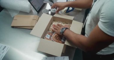 Çevrimiçi siparişler, yemek, çıkartma, nakliyeye hazırlık paketleri içeren Afrika kökenli Amerikan Nakliye ve Alıcı Karton Paketi 'nde Top View. E-ticaret mağazasının teslimat servisi..