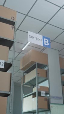 Posta Sıralama Merkezi, Online Mağaza Perakende Deposu raflarda karton kutularda E-Ticari Mallar. Depo, Lojistik, Dağıtım Teslimat Servisi. Dolly Shot. Dikey Çekim.