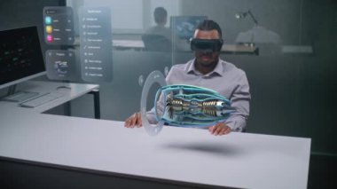 Afrikalı Amerikalı Mühendis Yenilenebilir Enerji Motorunun 3D Holografik Modelini Görüntülemek için Artırılmış Gerçeklik Kulaklığı Kullanıyor. Yapay Zeka Temelli Tasarım Yazılımının Sanal Görselleştirilmesi.