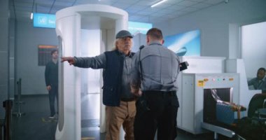 Uluslararası Havalimanı Terminalindeki Güvenlik Kontrolü Sırasındaki Yaşlı Adam: Uçağa binen yolcu için Güvenlik Görevlisi Yolcuyu Denetliyor. Arka planda, çeşitli gezginlerin kuyruğu Tatile çıkıyor