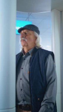 Havaalanı Terminali: Yaşlı Adam Metal Detektör Kapısı 'ndan Güvenlik Kontrol Noktasında Geçiyor. Güvenlik Subayı, Yolcu teftişini kontrol ediyor. Seyahate çıkan gezginler. Dikey Çekim.