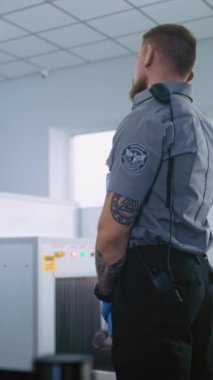 Havaalanı Terminali: Adam Metal Detektör Kapılarından Güvenlik Kontrol Noktasında Geçiyor. Güvenlik görevlisi yolcuları kontrol ediyor. Biniş için gerekli belgeler. Seyahate çıkan gezginler. Dikey Çekim.