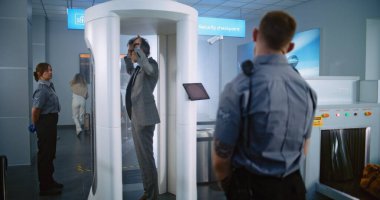 Havaalanı Terminali: Olgun Adam, Metal Detektör Kapılarından Güvenlik Kontrol Noktasında Geçiyor. Güvenlik görevlisi yolcuyu, evrakları, uçak biletini kontrol ediyor. Çeşitli Turistler Tatile Çıkıyor.