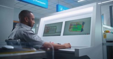 Afrika-Amerikalı Güvenlik Subayı, Modern Yazılım kullanarak Bilgisayar Monitörlerinde Bavul İçinde Şüpheli Öge Buluyor. Havaalanı Güvenlik Kontrol Noktasında Modern X-ray Tarama Teknolojisi.