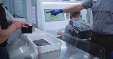 Uçuş sırasında havaalanı güvenliği kontrol noktası. Çeşitli Yolcular Plastik Tepsilere Kişisel Ait Eşyaları İnceleme için Tablet Bilgisayar, Telefon, Belgeler. Güvenlik Subayları Denetim Prosedürleri.