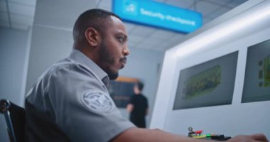 Havaalanı Terminali: Afrikalı Amerikalı Güvenlik Subayının Bilgisayar ekranlarında bagaj taraması yaparken Dolly 'nin fotoğrafı. Gemiye biniş için modern X-ışını taraması.