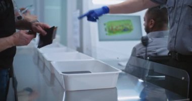 Uçağa biniş sırasında havaalanı güvenliği kontrol noktası. Çeşitli İnsanlar Plastik Tepsilere Kişisel Eşyalar Koy: Tablet Bilgisayar, Telefon, Belgeler. Güvenlik Subayları Denetim Prosedürleri.