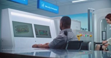 Afrikalı Amerikalı Güvenlik Subayı Modern Yazılım kullanarak Bilgisayar Monitörlerinde Bavul Gösterimini Denetliyor. Havaalanı Uçuş Kontrol Noktası 'ndaki Taşıyıcı Bantında Gelişmiş X-ray Tarama Teknolojisi