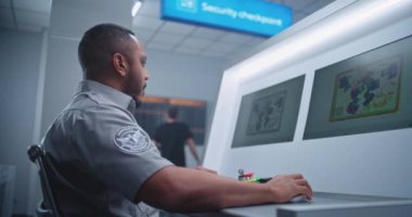 Havaalanı Terminali: Afro-Amerikan Güvenlik Subayı, Bavul 'da Bavul Ekranında Bavul Taramasını Gözetliyor, Şüpheli Eşya Buluyor. Güvenlik Kontrol Noktasındaki Modern X-ray Taşıyıcı Şeridi Taraması.