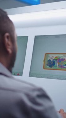 Havaalanı Terminali: Bilgisayarda bagaj taramasını izleyen Afrikalı Amerikan Güvenlik Subayı. Güvenlik Kontrol Noktasında X-ray Taraması için Modern Uygulamayı Gösteren Bilgisayar Ekranları. Dikey Çekim.