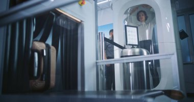 Havaalanı Güvenlik Kontrol Noktası: Yolcu bavulunu bavul taraması için X-ray konveyör bandına yerleştirdi, Metal dedektörü tarayıcı kapısından geçerek Uçuş için geçiş yaptı. Turist Tatile Çıkıyor.