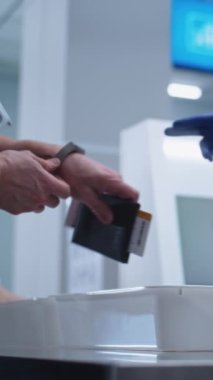 Uçuş sırasında havaalanı güvenliği kontrol noktası. Yolcular, Tarayıcı Tableti, Telefon ve Belgeler İçin Kişisel Ait Kılavuzlarını Tarayıcılar Tepsisine Koydular. Güvenlik Subayları Kontrol Prosedürleri. Dikey Çekim.