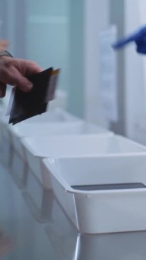 Uçuş sırasında havaalanı güvenliği kontrol noktası. Çeşitli İnsanlar İnceleme için Kişisel Eşyaları Tablet Bilgisayar, Telefon, Belgeler 'e koyarlar. Güvenlik Subayları Kontrol Prosedürleri. Dikey Çekim.
