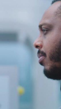 Havaalanı Güvenlik Kontrol Noktası: Afrikalı Amerikalı Güvenlik Subayı Yolcu Gösterimini İzliyor. Metal dedektöründen geçen kadına odaklanın. Uçağa biniş için tarama yapın. Dikey Çekim.