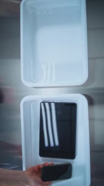 Kişisel Ögeleri Plastik Tepsiye yerleştiren Yolcuların En İyi Görünümü: Tablet Bilgisayar, Telefon, Çanta. Uçağa binmeden önce havaalanı güvenliği kontrol noktası. Güvenlik Subayı Prosedürü Denetliyor.