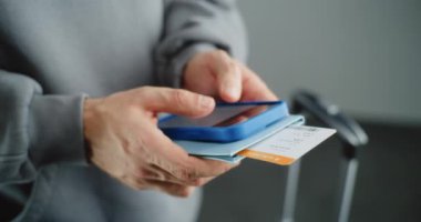 Havaalanı Terminali: Bilinmeyen Adam Tutma Belgelerini Ellerinde Biletle Kapatmak, Akıllı Telefon kullanarak Uçuş Bilgilerini Kontrol Etmek, İnternet veya Sosyal ağlarda sörf yapmak. Gezgin Seyahate Çıkıyor.
