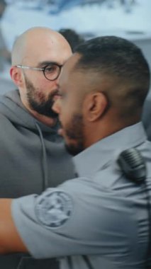 Havaalanı Terminali Güvenlik Kontrol Noktası: Afro-Amerikan Güvenlik Subayı Metal Detektörü Kapıları Taradıktan sonra Şüpheli Eşyalar İçin Adamın Vücudunu Denetliyor. TSA tarama prosedürleri. Dikey Çekim.