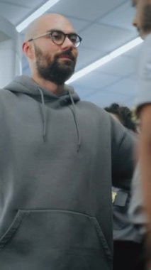 Havaalanı Güvenlik Kontrol Noktası: Afro-Amerikan Güvenlik Görevlisi Yolcu Bedeninde Metal Detektör Tarayıcısından sonra Tehlikeli Eşyalar Var mı diye Kontrol Etti. TSA tarama prosedürleri. Gezgin Seyahate Çıkıyor. Dikey Çekim.