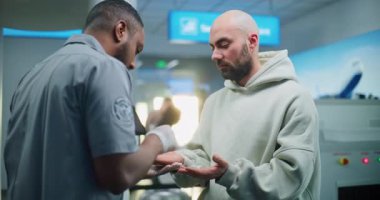 Havaalanı Terminali: Afro-Amerikan Güvenlik Subayı, TSA el temizleme işlemini Fırçayla Erkek Yolcu 'ya uçuş için yapıyor. Patlayıcı madde kalıntılarını tanımlamak için ETD prosedürü. Ortam Kapalı.