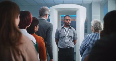 Havalimanı Güvenlik Kontrol Noktası: Afro-Amerikan Güvenlik Subayı çeşitli insanlara, yolculara uçağa binmek için TSA tarama prosedürleri hakkında bilgi veriyor. Tatil gezilerine çıkan Gezginler Kuyruğu.