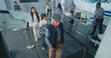 Havaalanında Güvenlik Kontrolü: Çeşitli Etnik Halkın Kuyruğu, Ulaşım Güvenliği İdaresi Tarama Yöntemleri. Havaalanı personeli yolcuları, yolcuları kontrol ediyor. Güvenlik kamerasına odaklan. Yüksek Açı.