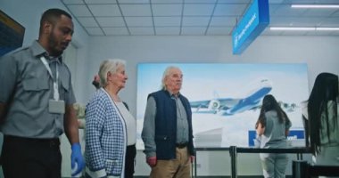 Havaalanı Terminali 'ndeki güvenlik kontrol noktası Metal Detektör Kapısı' ndan geçen çeşitli insanlar, Yolcuları kontrol eden güvenlik görevlileri. TSA tarama prosedürlerini bekleyen turist kuyruğu. Doli Vuruşu.