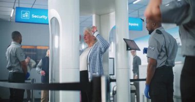 Havaalanındaki TSA Güvenlik Hattı: Metal Detektör Kapılarından Yürüyen Yaşlılar. Güvenlik Subayları, Tablet Bilgisayar kullanarak Yolcu İzleme Prosedürünü Kontrol Ediyor..