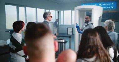 Havaalanı Güvenlik Kontrol Noktası: Afro-Amerikan Güvenlik Subayı TSA Tarama Prosedürlerini ve Çeşitli Kişilere Uçuş Yolcularını Açıkladı. Tatil gezilerine çıkan Gezginler Kuyruğu.