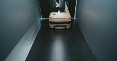 Havaalanı Terminalindeki Güvenlik Kontrol Noktası: Gelişmiş Metal Detektör X-ray Tarayıcısının içinde Konveyör Şeridinde ilerleyen Yolcu Bavulu ve Çantası. Uçağa binmek için bagaj tarama prosedürü.