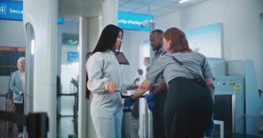 Havaalanındaki güvenlik kontrol noktası, Asyalı Kadın Tarama Kapılarından Geçiyor. Bayan Güvenlik Görevlisi, Yolcu İndirme Uçuşu, Cep Telefonu Bulma. TSA Tarama Prosedürleri.