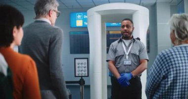 Havalimanı Güvenlik Kontrol Noktası: Afro-Amerikan Güvenlik Subayı, çeşitli kişilere, yolculara, TSA Uçuş Tarama Prosedürleri ile ilgili talimatlar verdi. Turistler Tatile Gidiyor.