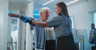 Havaalanı Terminali 'ndeki güvenlik kontrol noktası: Metal Detektörü Kapıları taradıktan sonra çeşitli güvenlik görevlileri yolcuları kontrol ediyor. Uçağa binmek için Ulaşım Güvenliği İdaresi İnceleme Prosedürleri. Turist Tatile Çıkıyor.