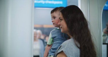 Havaalanı Terminali 'ndeki TSA Güvenlik Hattı: X-ray Metal Detektör Kapıları' ndan geçen çocuklu bir kadın. İnsan Vücut Tarama Prosedürü. Turistler Tatile Gidiyor.