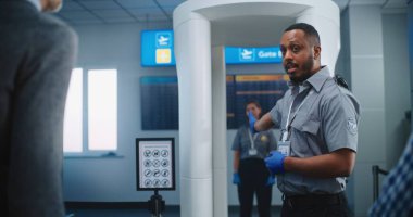 Havalimanı Güvenlik Kontrol Noktası: Afro-Amerikan Güvenlik Subayı, çeşitli kişilere, yolculara, TSA Uçuş Tarama Prosedürleri ile ilgili talimatlar verdi. Turistler Tatile Gidiyor.