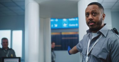 Havaalanı Güvenlik Kontrol Noktası: Pozitif Afro-Amerikan Güvenlik Görevlisi, çeşitli kişilere ve yolculara, uçağa biniş için TSA tarama prosedürleri hakkında bilgi verdi. Gezginlerin Kuyruğu Gezintiye Çıkıyor