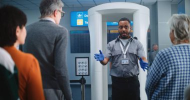 Havalimanı Güvenlik Kontrol Noktası: Afro-Amerikan Güvenlik Subayı, çeşitli kişilere, yolculara, TSA Uçuş Tarama Prosedürleri ile ilgili talimatlar verdi. Turistler Tatile Gidiyor.