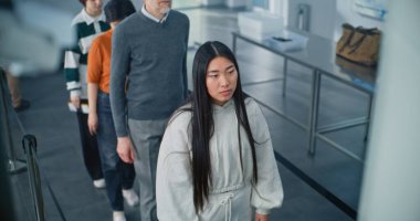 Havaalanı Terminali 'nde güvenlik kontrolü: Çeşitli Etnik Etkinliğe sahip kişilerin kuyruğu, Metal Detektörü Tarama Kapıları için Cinsiyet Standı. Ulaşım Güvenliği Güvenliği İdaresi 'nin uçuş prosedürü sırasındaki yolcular. Yüksek Açı.