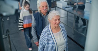 Havaalanı Terminalindeki Güvenlik Kontrol Noktası: Çeşitli İnsanlar Kuyruğu, Metal Detektörü Tarama Kapıları İçin Bekleyen Turistler. Uçağa binmek için Ulaşım Güvenliği Güvenliği İdaresi İnceleme prosedürü sırasında yolcular. Yüksek Açı.