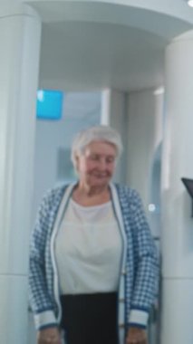 Havaalanı Terminali 'ndeki güvenlik kontrol noktası: Kadın güvenlik görevlisi, Metal Detektörü Kapıları Taradıktan sonra Uçak Uçuşu için Yaşlı Kadın Denetliyor. TSA tarama prosedürleri. Gezgin Tatile Çıkıyor.