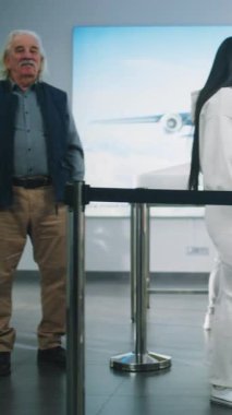 Havaalanı Terminali 'ndeki güvenlik kontrol noktası Metal Detektör Kapısı' ndan geçen çeşitli insanlar, Yolcuları kontrol eden güvenlik görevlileri. TSA tarama prosedürlerini bekleyen turistler. Dikey Çekim.