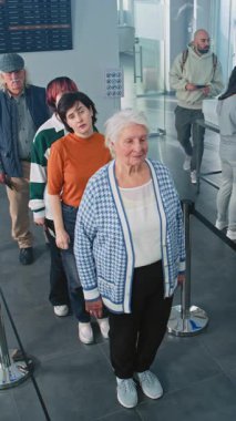 Havaalanı Terminalindeki Güvenlik Kontrol Noktası: Çeşitli İnsanlar, TSA Tarama Prosedürlerinde Turistler Kuyruğu. Güvenlik görevlileri yolcuları kontrol ediyor. Kameraya odaklan, tamam mı? Yüksek Açı. Dikey Çekim.