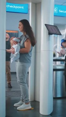 Havaalanı Terminali: Metal dedektöründen geçen iki çocuklu aile. Güvenlik Subayı, Yolcuyu Tablet Bilgisayar 'da yolcu uçağına binmek için kontrol ediyor. Gezginlerin Kuyruğu Ekranı Bekliyor.