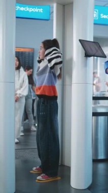 Havaalanı Güvenlik Kontrol Noktası: Metal dedektöründen geçen çok ırklı yolcular. Havaalanı Personel Kontrolü İnsanlar Tablet Bilgisayar kullanarak Uçak Uçuş Tarama Prosedürü. Dikey Çekim.