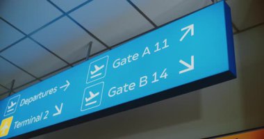 Yolcuları Kalkış, Terminaller ve Kapılara yönelten Parlak Mavi Led tabelası. Yoğun Modern Uluslararası Havaalanı Terminali 'nde Navigasyon İşareti. Kapat..