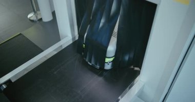 Modern Havalimanı Terminali 'ndeki Güvenlik Kontrol Noktası: Gelişmiş Metal Detektörü X-ray Tarayıcısından Yolcu Bavulu Taşıma Kayışı. Uçağa binmeden önce bavul tarama prosedürü. Yüksek Açı.
